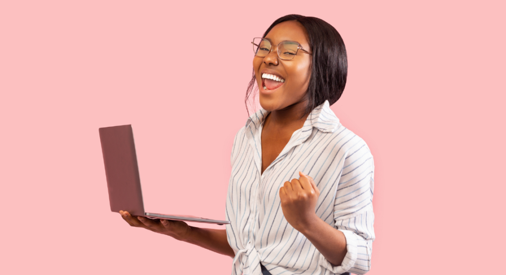 Tips To Win Your First Client as Freelancer, standing woman holding her laptop with a winning smile